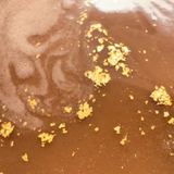 Close-up of a brown substance with gold flakes