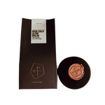 Rose gold glow balm with packaging on a white background