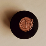 Black container with a brown logo on a beige background