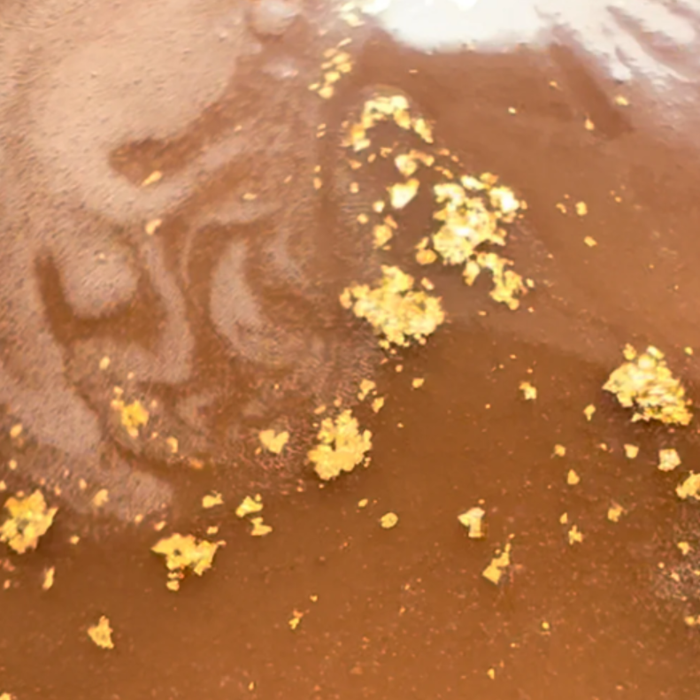 Close-up of a brown substance with gold flakes