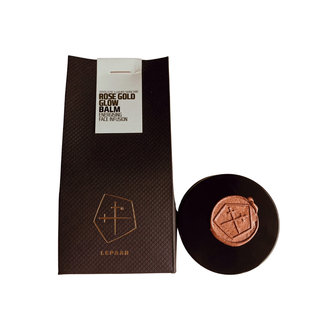 Rose gold glow balm with packaging on a white background