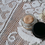 Maryse Dew Illuminator with open lid surrounded by daisies- Margot Body